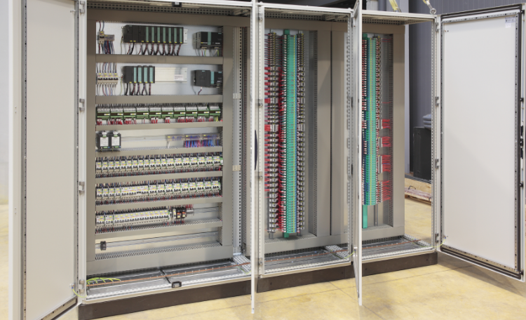 Large electrical control panel with PLC shown as an example of the company’s panel manufacturing capability.