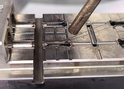 Closeup of laser welding performed on a small part.