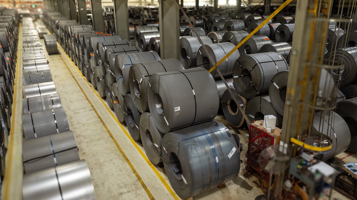 Steel coil loading and shipment handling in an industrial warehouse.