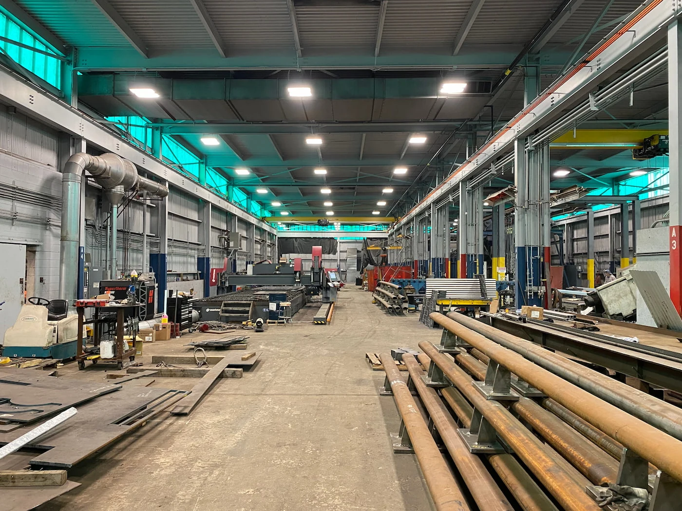 Heavy fabrication shop with structural steel work areas and overhead material handling at Mohawk Northeast.