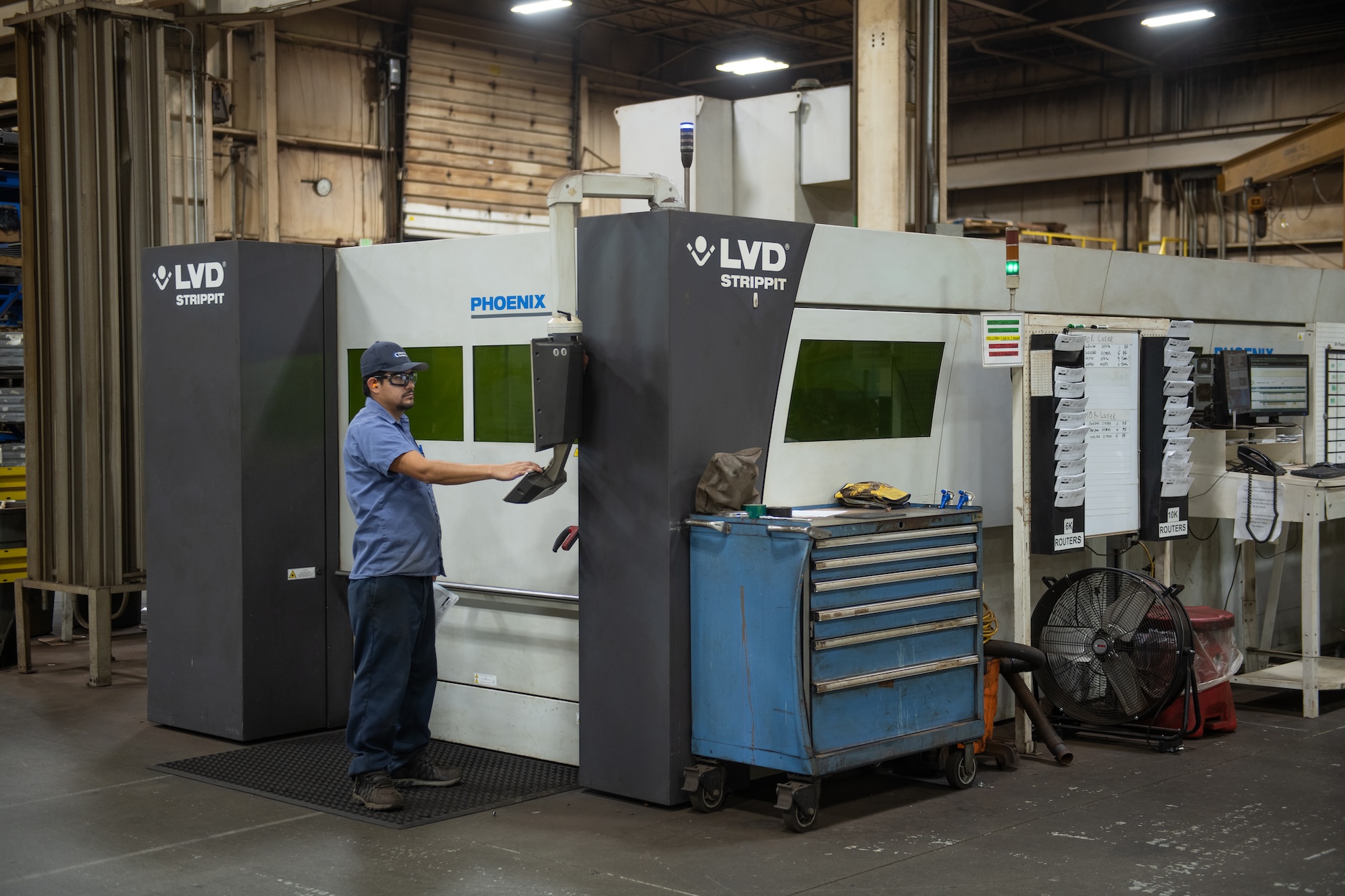 Operator setting up an LVD fiber laser for sheet metal cutting.