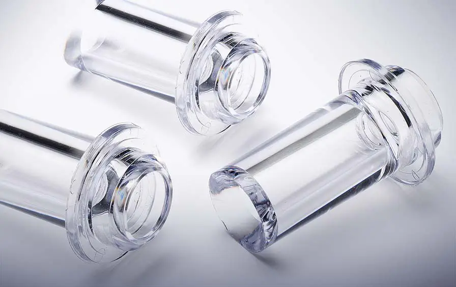 Clear injection-molded flanged sleeves with high clarity, uniform walls, and flash-free sealing rims for leak-tight assemblies.