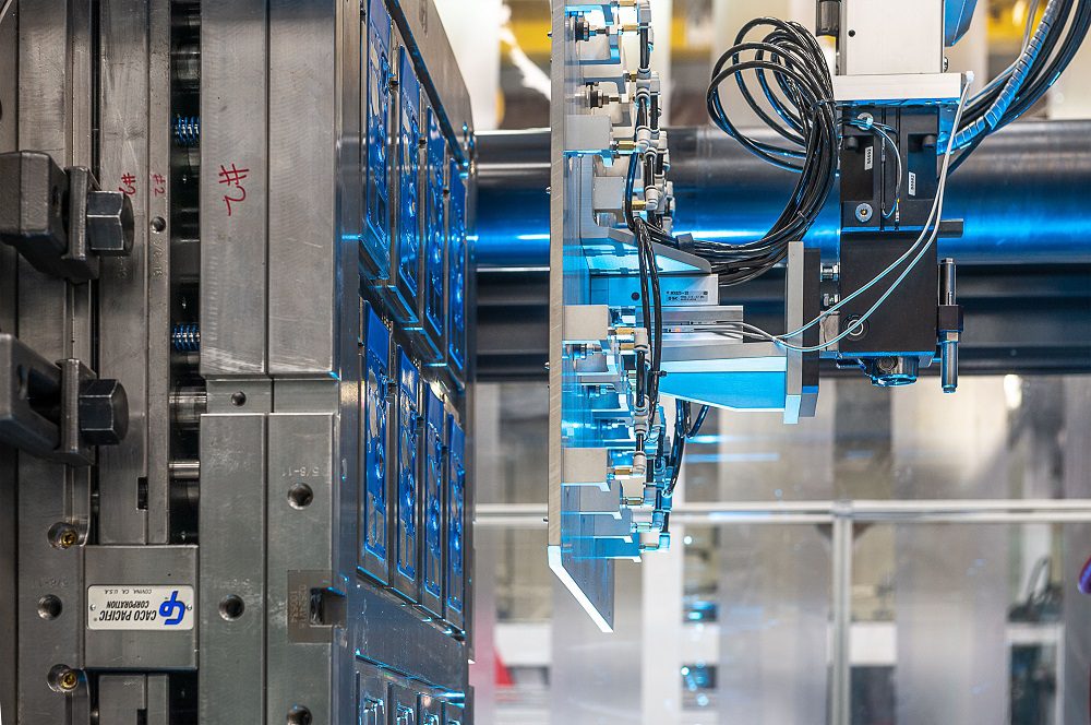 Robotic end-of-arm tool degating plastic components inside a multi-cavity injection mold at Westec Plastics